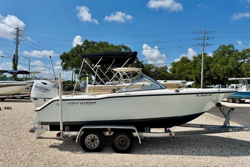 Slide: The Image of 2016 Key West 203 DFS boat on trailer with Suzuki engine, parked outdoors. - 7
