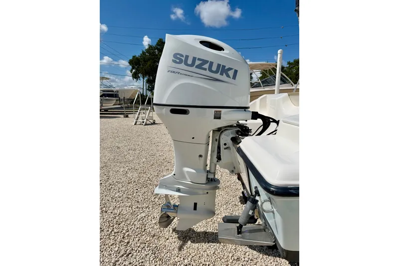 Slide: The Image of 2016 Key West 203 DFS boat with Suzuki outboard motor in a sunny outdoor setting. - 32