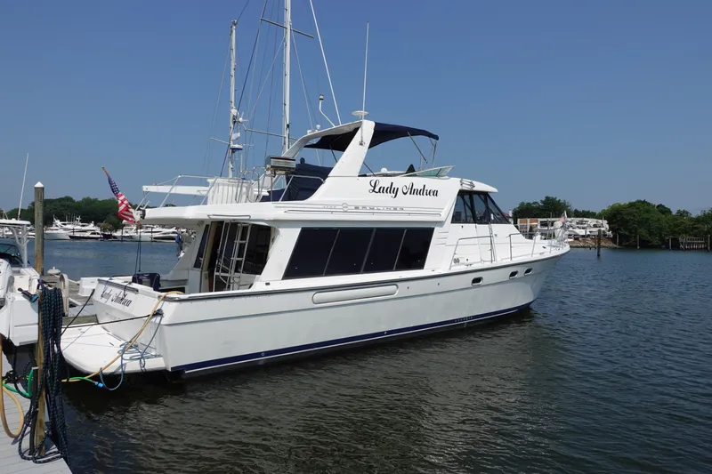 Slide: The Image of 2000 Bayliner 4788 Pilot House Motoryacht docked in a marina under clear blue skies. - 2