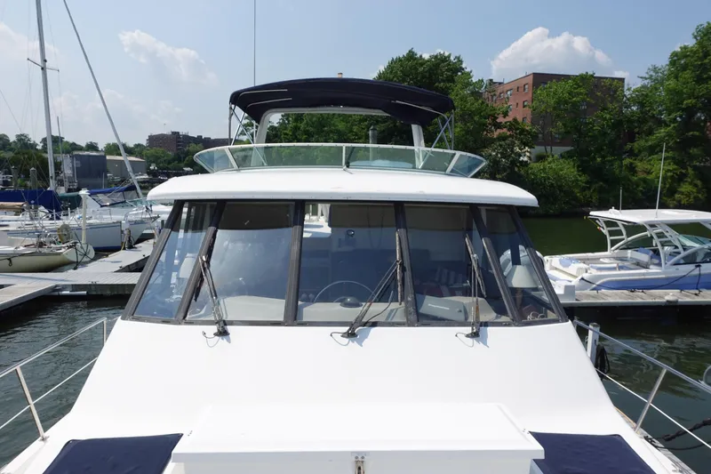 Slide: The Image of 2000 Bayliner 4788 Pilot House Motoryacht docked at marina under clear sky. - 6