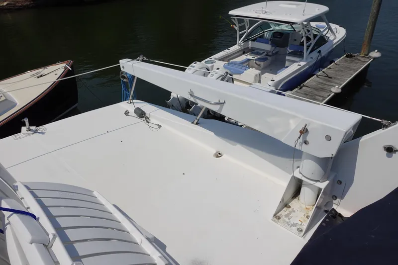 Slide: The Image of Bayliner 4788 Pilot House Motoryacht 2000 docked, showcasing spacious deck and nearby boats. - 12