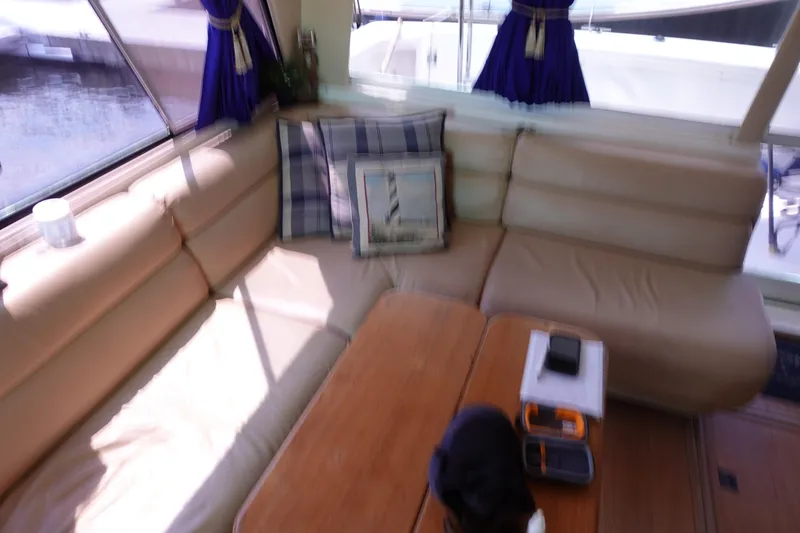 Slide: The Image of Interior of 2000 Bayliner 4788 Pilot House Motoryacht with beige seating and wooden table. - 33