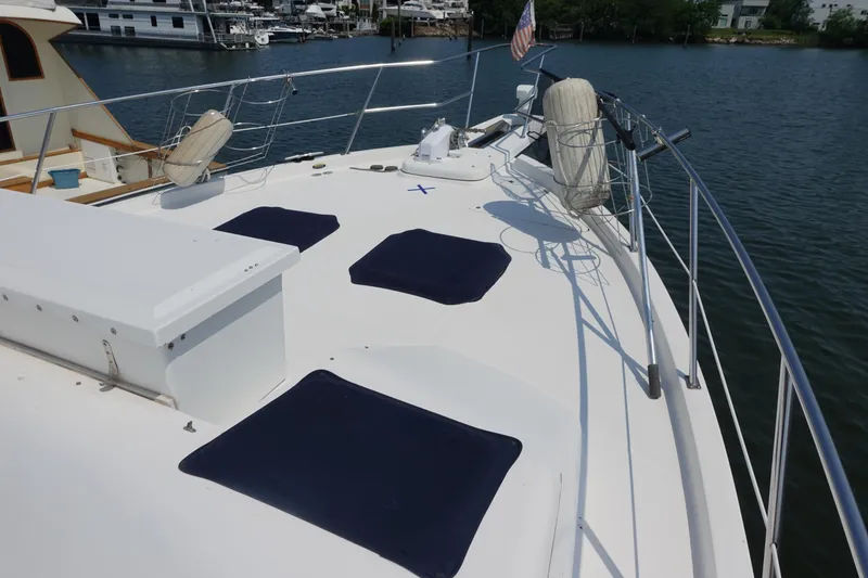 Slide: The Image of 2000 Bayliner 4788 Pilot House Motoryacht deck with seating, docked by the water. - 5