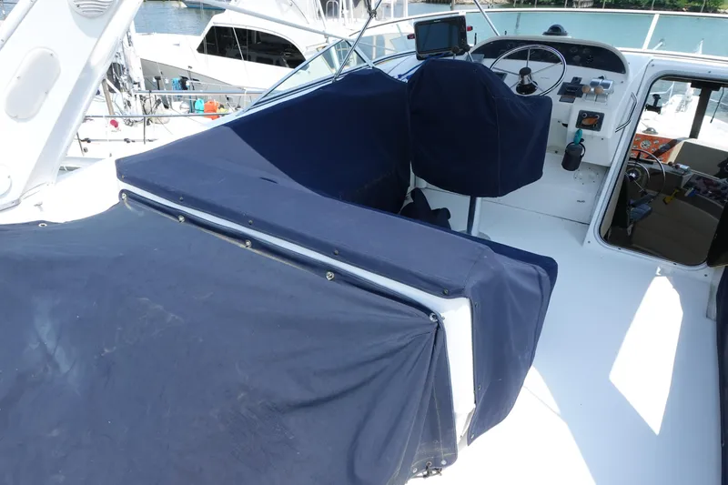 Slide: The Image of 2000 Bayliner 4788 Pilot House Motoryacht helm with blue covers and navigation equipment. - 15