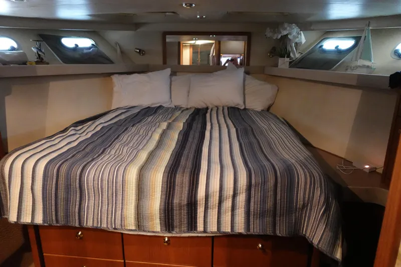 Slide: The Image of Cozy bedroom in 2000 Bayliner 4788 Pilot House Motoryacht with striped bedding and porthole windows. - 20