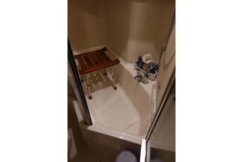 Slide: The Image of Shower area in 2000 Bayliner 4788 Pilot House Motoryacht with wooden seat and handheld showerhead. - 25