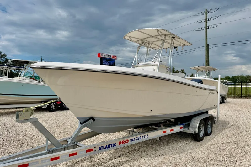 Slide: The Image of 2020 Cobia 237 Center Console boat on trailer, displayed outdoors under cloudy sky. - 1