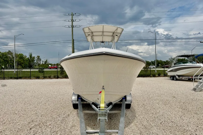 Slide: The Image of 2020 Cobia 237 Center Console boat on trailer, parked outdoors under cloudy sky. - 2