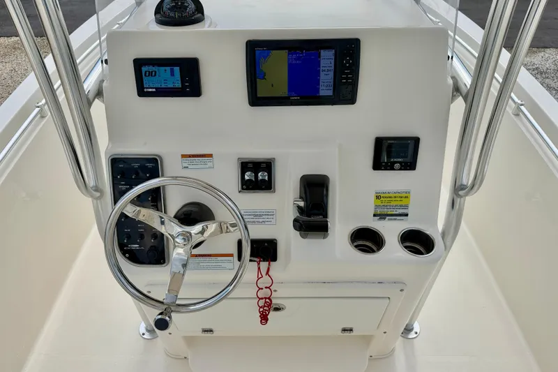Slide: The Image of 2020 Cobia 237 Center Console boat dashboard with steering wheel and navigation controls. - 18