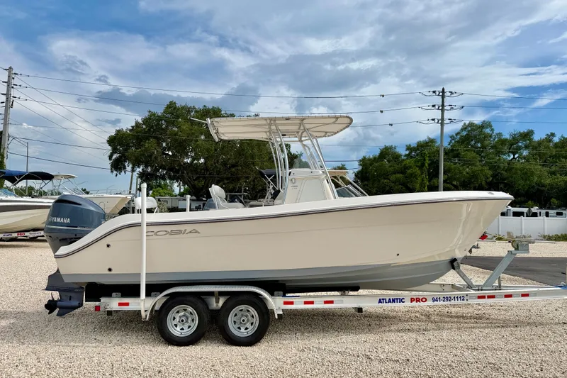 Slide: The Image of 2020 Cobia 237 Center Console boat on trailer, featuring Yamaha engine, parked outdoors. - 4