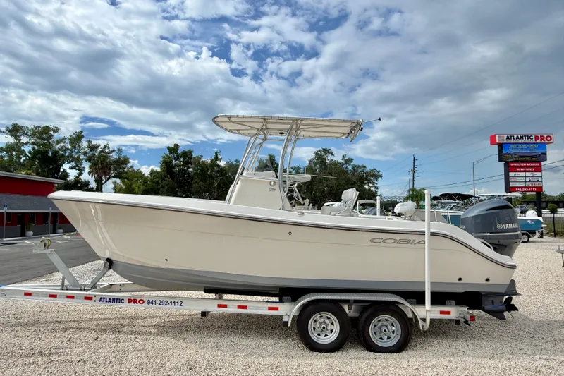 The Image of 2020 Cobia 237 Center Console boat on trailer under cloudy sky. - 0
