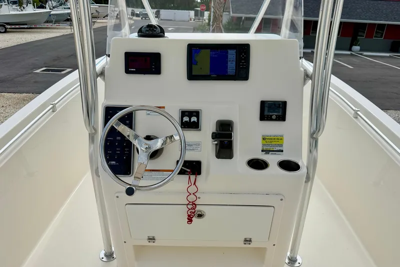 Slide: The Image of 2020 Cobia 237 Center Console boat dashboard with steering wheel and navigation controls. - 17