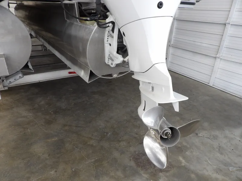 Slide: The Image of An outboard motor with a three-blade propeller is mounted on a pontoon boat. The floor is concrete. - 19