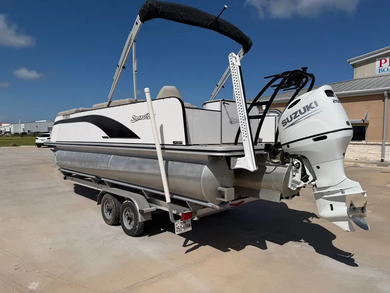 Slide: The Image of A 2022 SilverWave 2410 RLP SW3 pontoon boat on a trailer, featuring a Suzuki outboard motor. - 27