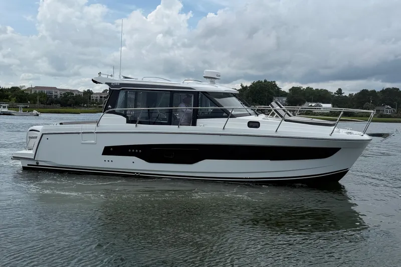 Slide: The Image of 2026 Jeanneau NC 1095 Coupe boat on calm water, side view. - 55