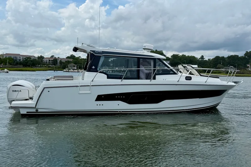 Slide: The Image of 2026 Jeanneau NC 1095 Coupe boat on calm water, side view. - 56