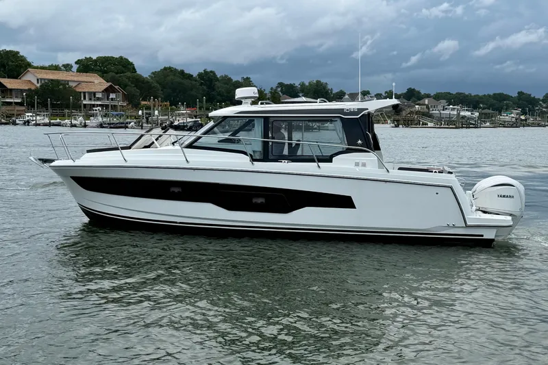 Slide: The Image of 2026 Jeanneau NC 1095 Coupe boat on calm water, featuring sleek design and Yamaha engines. - 63