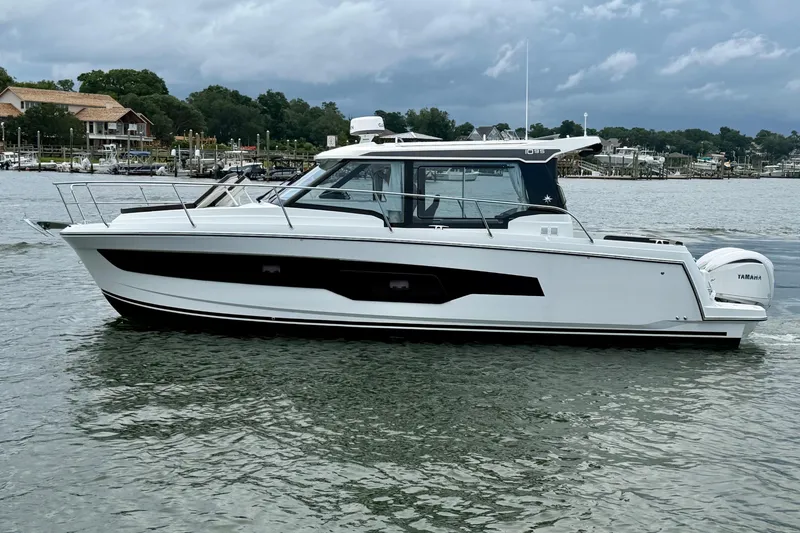 Slide: The Image of 2026 Jeanneau NC 1095 Coupe boat on calm water, showcasing sleek design and modern features. - 62