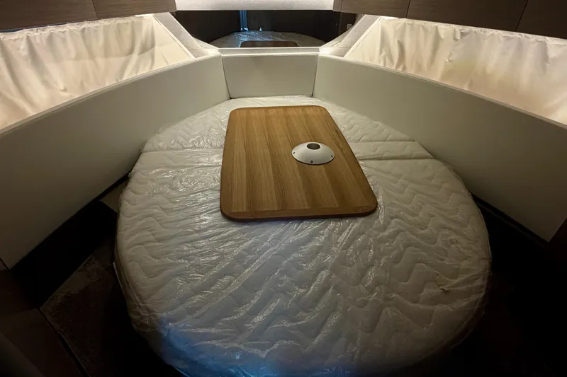 Slide: The Image of Interior cabin of 2026 Jeanneau NC 1095 Coupe with a wooden table and cushioned seating. - 105