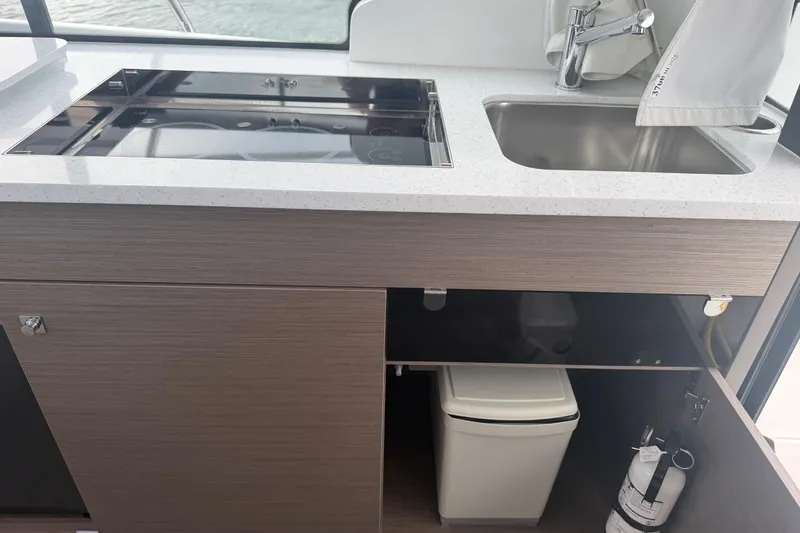 Slide: The Image of Modern kitchen area in 2026 Jeanneau NC 1095 Coupe boat with sink and stove. - 98