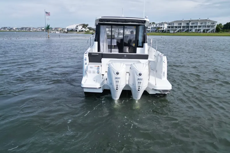 Slide: The Image of 2026 Jeanneau NC 1095 Coupe with dual outboard engines on water. - 6