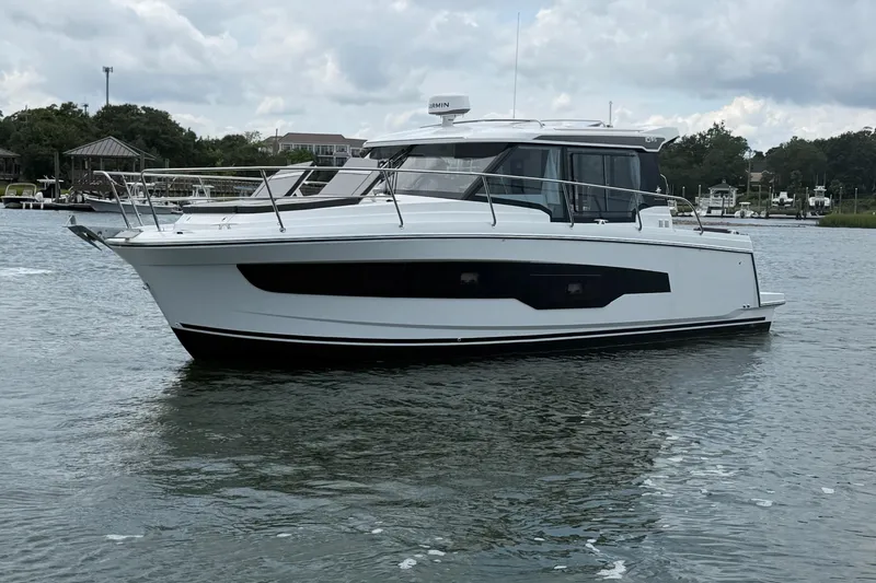 Slide: The Image of 2026 Jeanneau NC 1095 Coupe boat on calm water, overcast sky. - 51