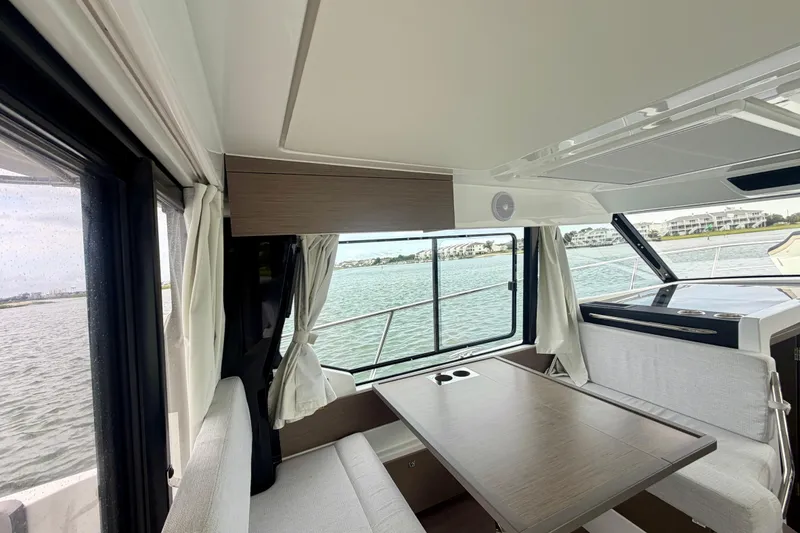 Slide: The Image of Interior of 2026 Jeanneau NC 1095 Coupe yacht with dining area and scenic water view. - 94