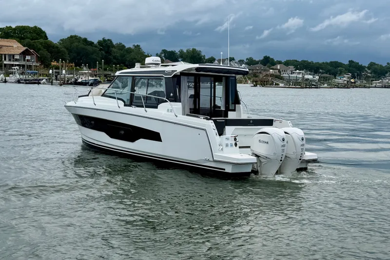 Slide: The Image of 2026 Jeanneau NC 1095 Coupe cruising on a calm river with scenic background. - 68