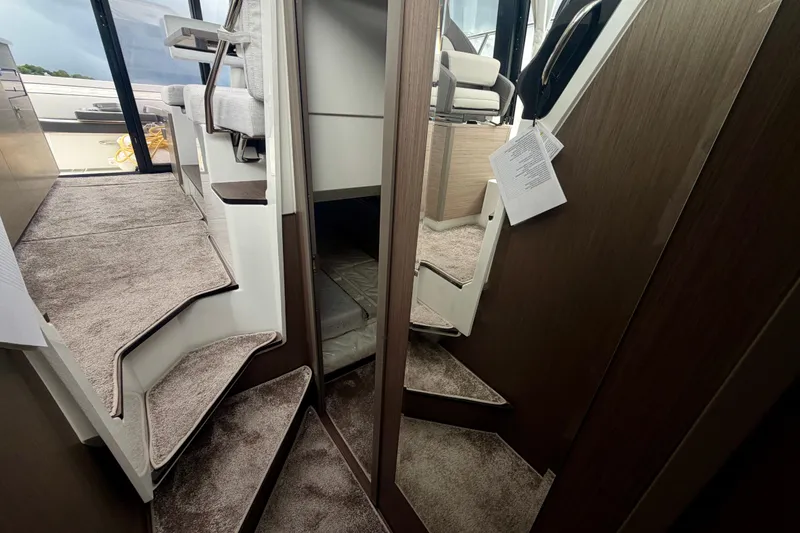 Slide: The Image of Interior view of 2026 Jeanneau NC 1095 Coupe, featuring carpeted stairs and modern design. - 110