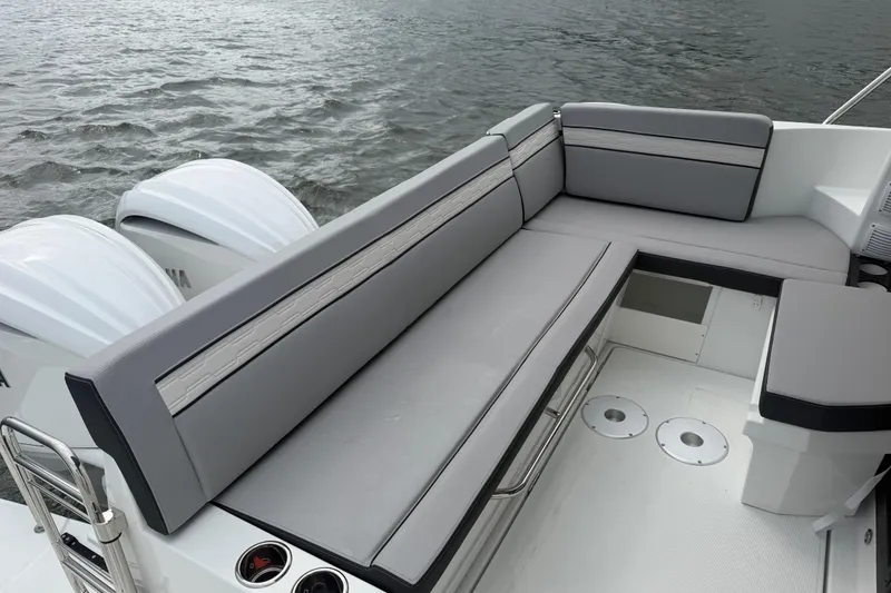 Slide: The Image of 2026 Jeanneau NC 1095 Coupe boat with sleek gray seating and dual outboard motors. - 82