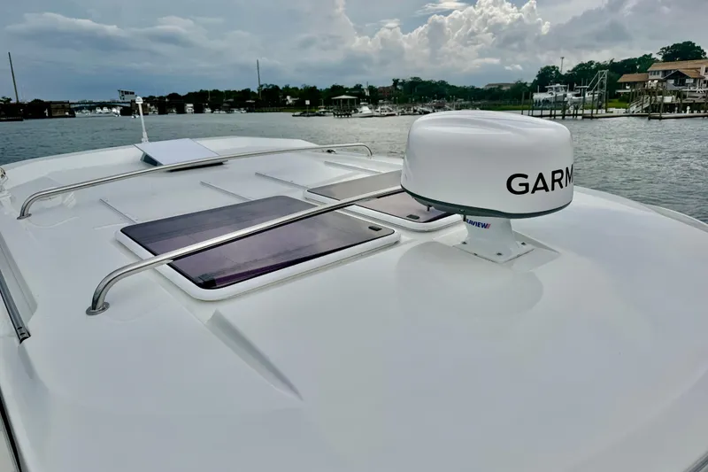 Slide: The Image of 2026 Jeanneau NC 1095 Coupe boat with Garmin radar on deck, docked by the waterfront. - 73