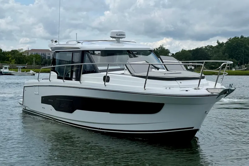 Slide: The Image of 2026 Jeanneau NC 1095 Coupe boat on calm water under cloudy sky. - 54
