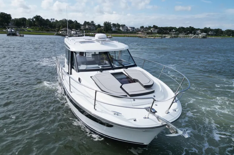 Slide: The Image of 2026 Jeanneau NC 1095 Coupe cruising on a scenic waterway. - 13