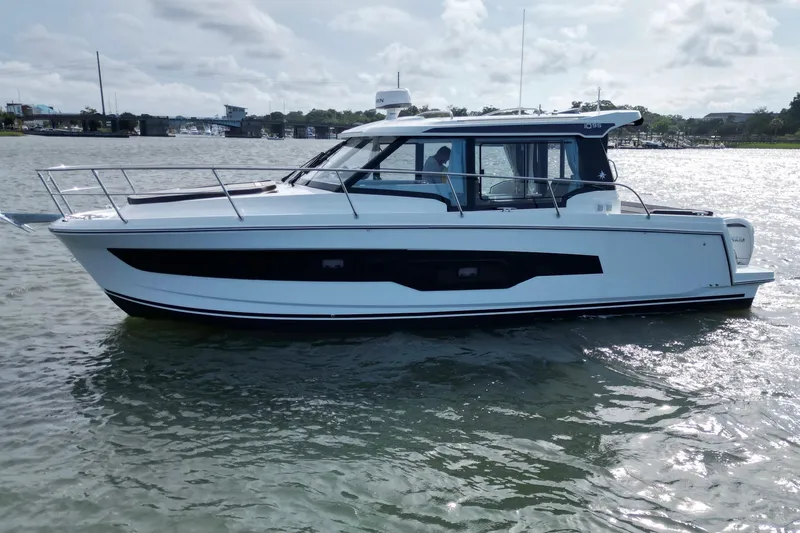 Slide: The Image of 2026 Jeanneau NC 1095 Coupe boat cruising on a sunny day. - 2