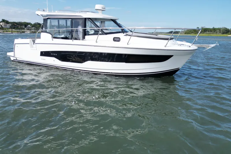 Slide: The Image of 2026 Jeanneau NC 1095 Coupe cruising on calm waters under a clear sky. - 11