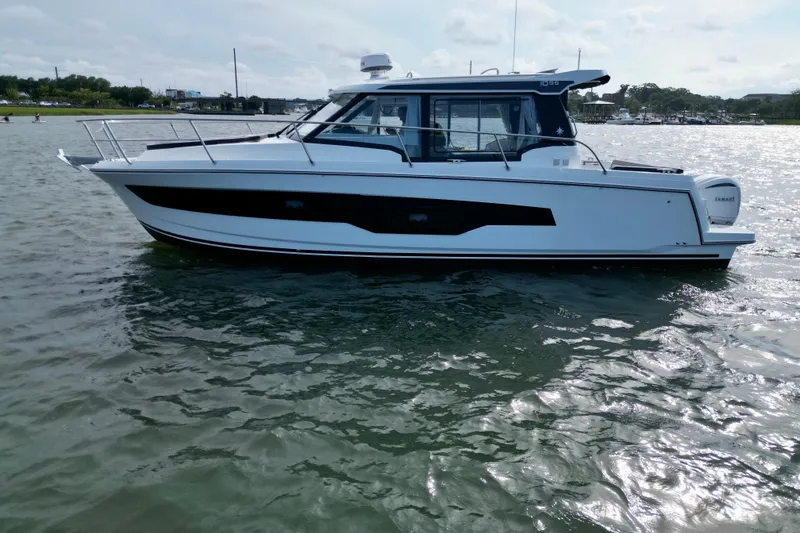 Slide: The Image of 2026 Jeanneau NC 1095 Coupe boat on calm water, side view. - 3