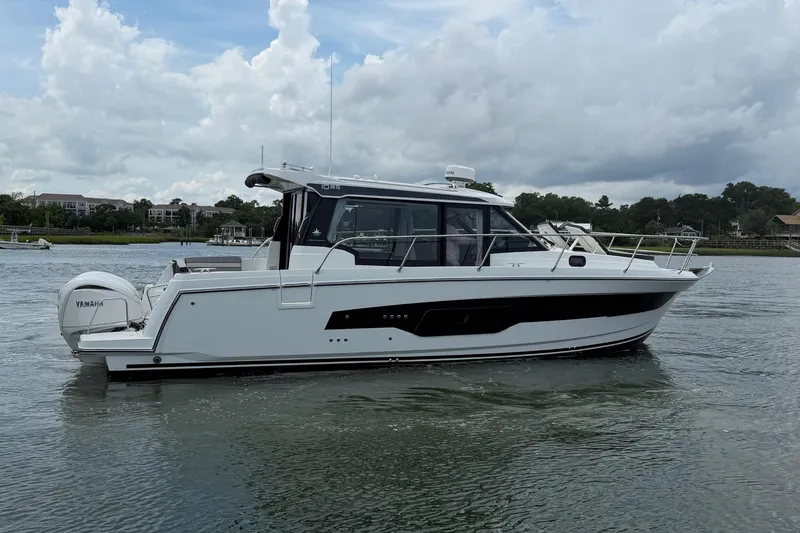 Slide: The Image of 2026 Jeanneau NC 1095 Coupe boat on calm water, side view. - 57