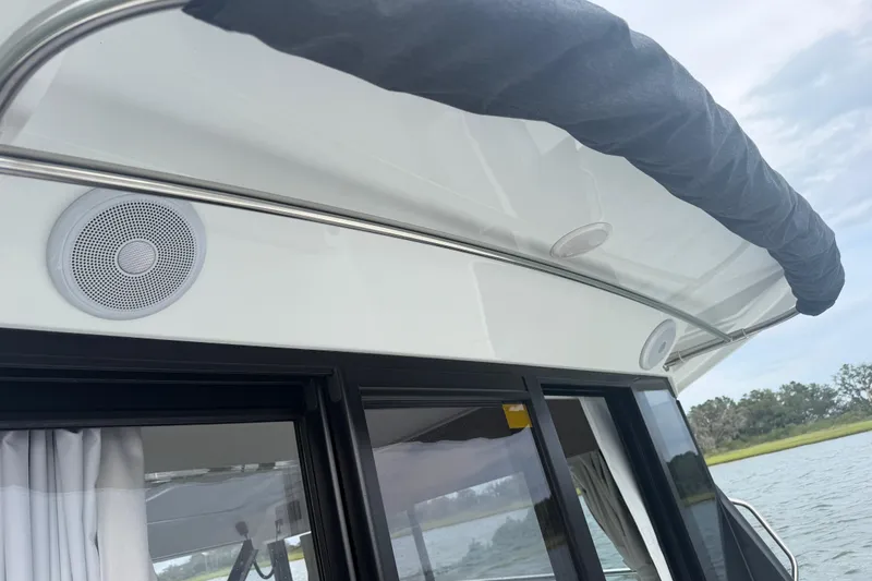 Slide: The Image of 2026 Jeanneau NC 1095 Coupe boat exterior with speakers and covered railing. - 87