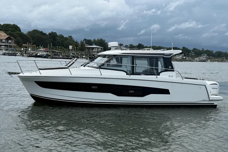 Slide: The Image of 2026 Jeanneau NC 1095 Coupe boat on calm water, cloudy sky background. - 60