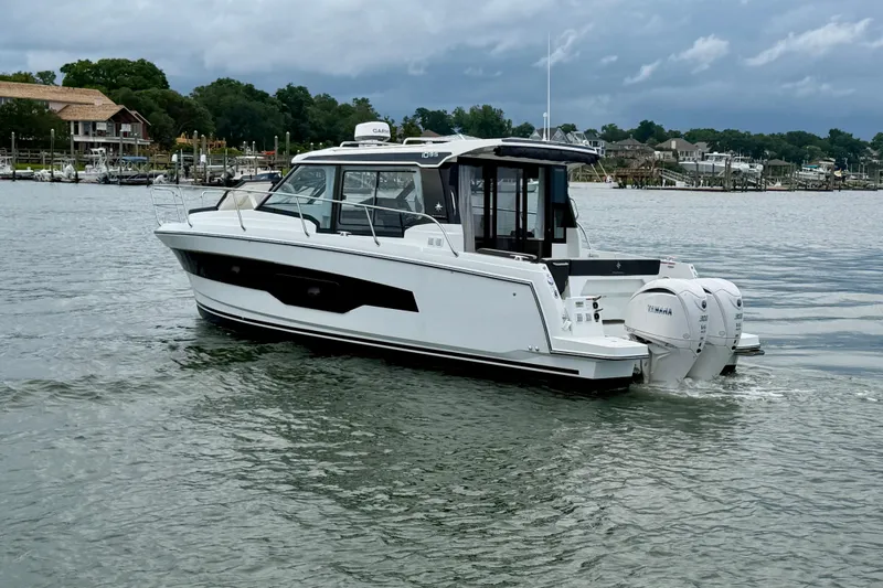 Slide: The Image of 2026 Jeanneau NC 1095 Coupe boat cruising on a calm river. - 67