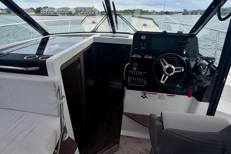 Slide: The Image of Interior view of 2026 Jeanneau NC 1095 Coupe boat cockpit with steering wheel and controls. - 101