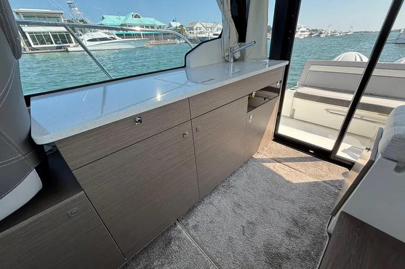 Slide: The Image of Interior of 2026 Jeanneau NC 1095 Coupe Series 2 with sleek cabinetry and waterfront view. - 26