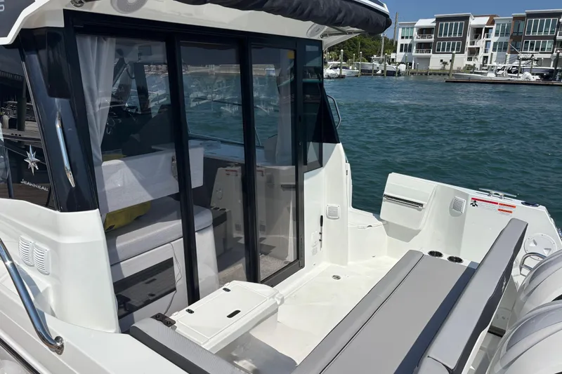 Slide: The Image of 2026 Jeanneau NC 1095 Coupe Series 2 boat with sleek design, docked by waterfront homes. - 5