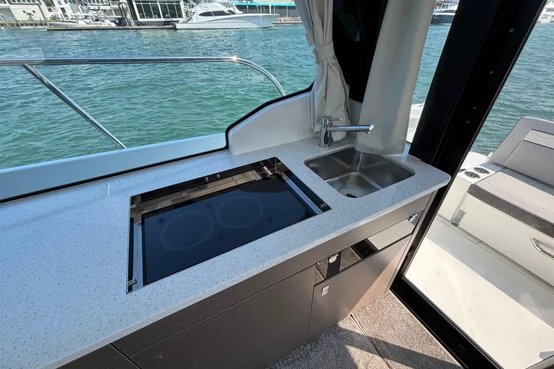 Slide: The Image of Modern kitchenette on 2026 Jeanneau NC 1095 Coupe Series 2 yacht, featuring stove and sink. - 28
