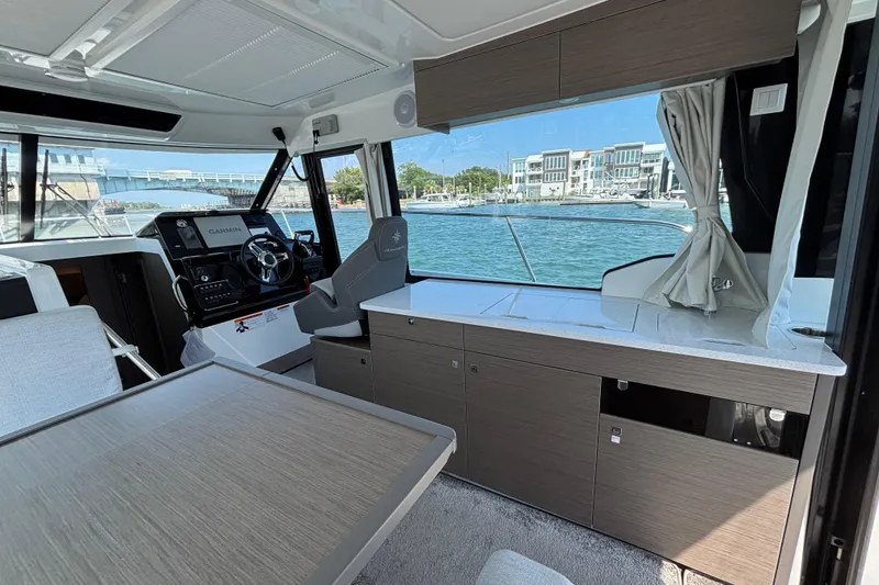 Slide: The Image of Interior of 2026 Jeanneau NC 1095 Coupe Series 2 with modern helm and waterfront view. - 8