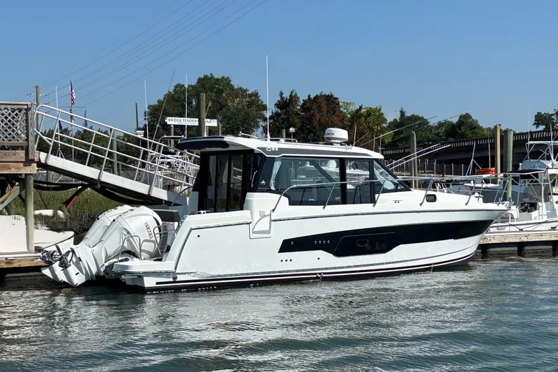 Slide: The Image of 2026 Jeanneau NC 1095 Coupe Series 2 docked at marina, side view. - 2
