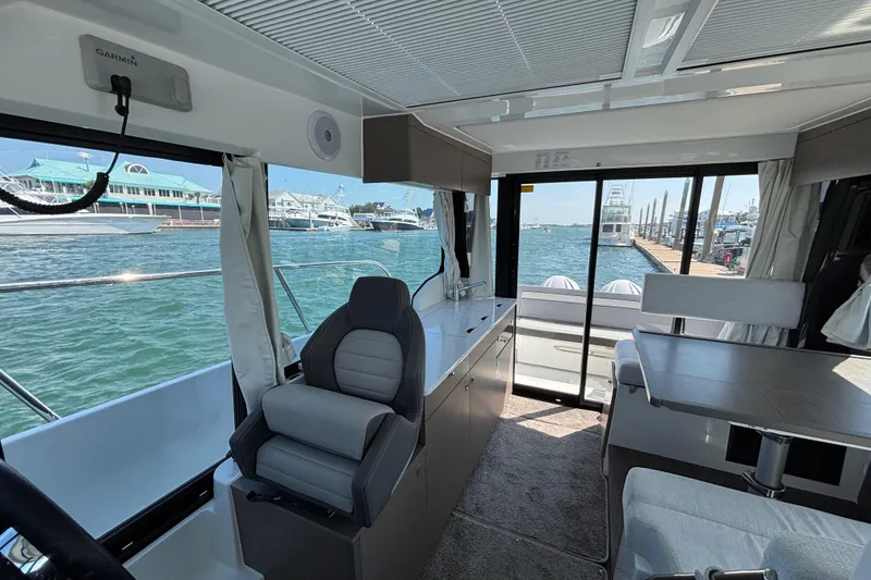 Slide: The Image of Interior of 2026 Jeanneau NC 1095 Coupe Series 2 boat, featuring modern seating and waterfront view. - 11
