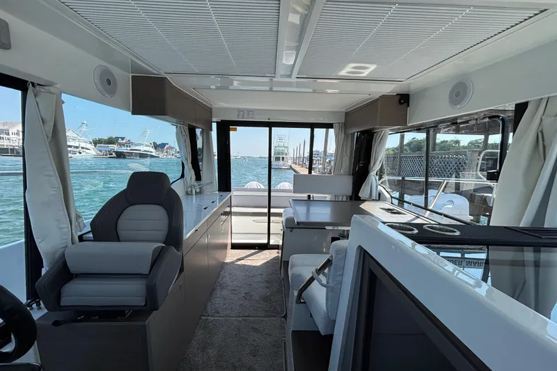 Slide: The Image of Interior of 2026 Jeanneau NC 1095 Coupe Series 2, featuring modern seating and large windows. - 10