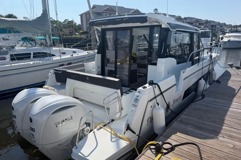 The Image of 2026 Jeanneau NC 1095 Coupe Series 2 docked, featuring twin Yamaha outboard engines. - 0