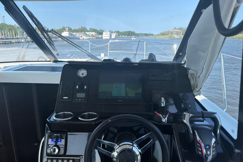 Slide: The Image of Helm of 2026 Jeanneau NC 1095 Coupe Series 2 with navigation controls and river view. - 7